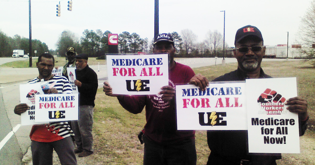 A group of Black men holding signs demanding Medicare for All