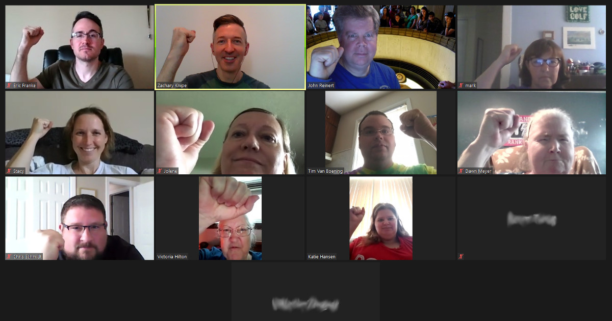 UE Local 808 members raise fists on a Zoom meeting