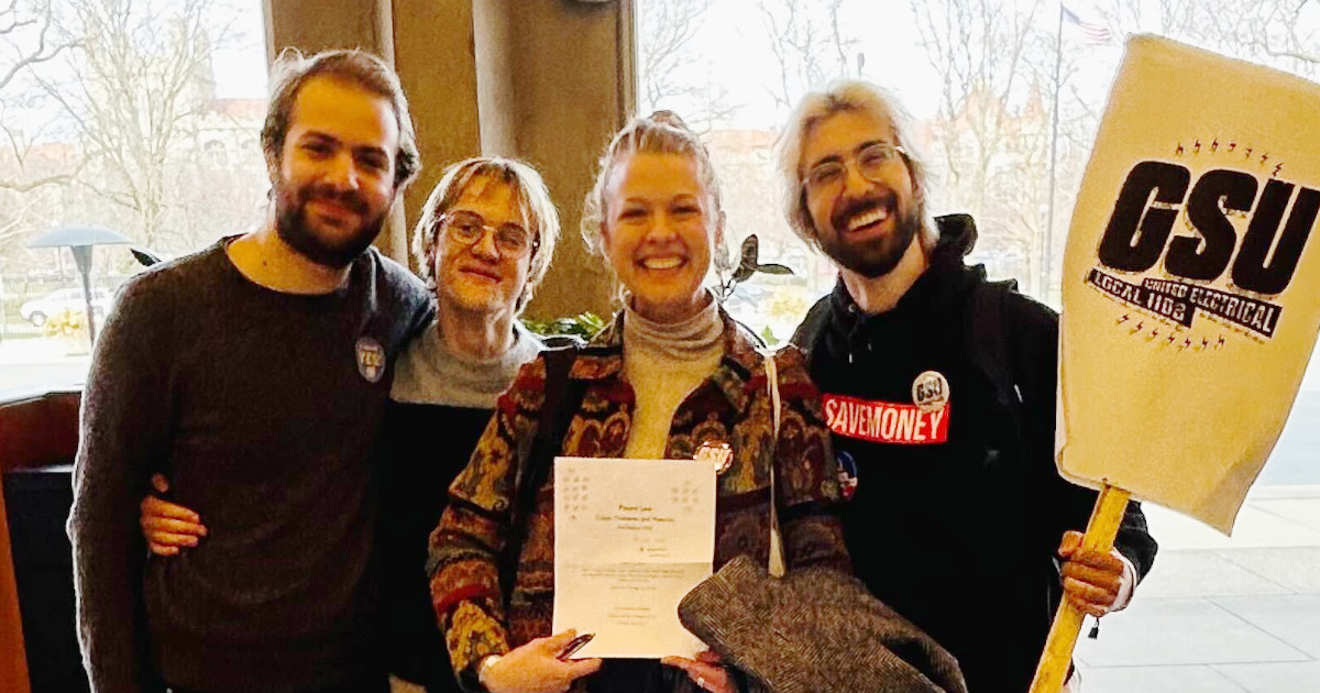 Four law student research assistants displaying a piece of paper with a vote tally