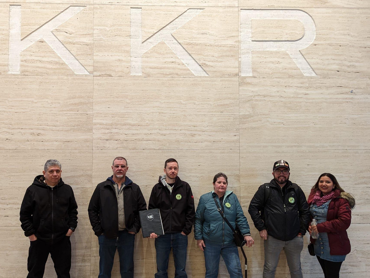 UE Local 115 members standing in front of KKR sign