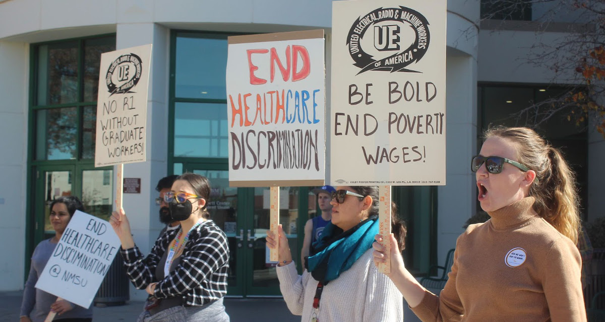 New Mexico State University graduate workers with signs reading End Healthcare Discrimination and Be Bold End Poverty Wages!