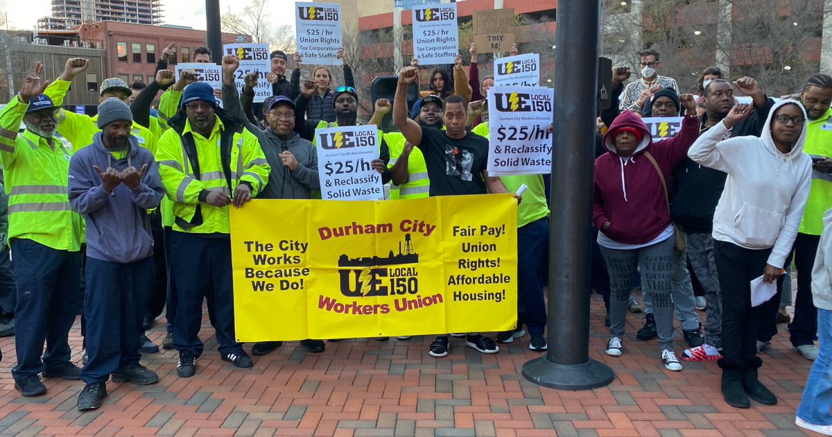 UE Local 150 members rallying with signs demanding $25/hour
