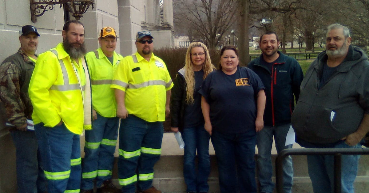 A group of UE Local 170 members, several of whom are wearing yellow work vests