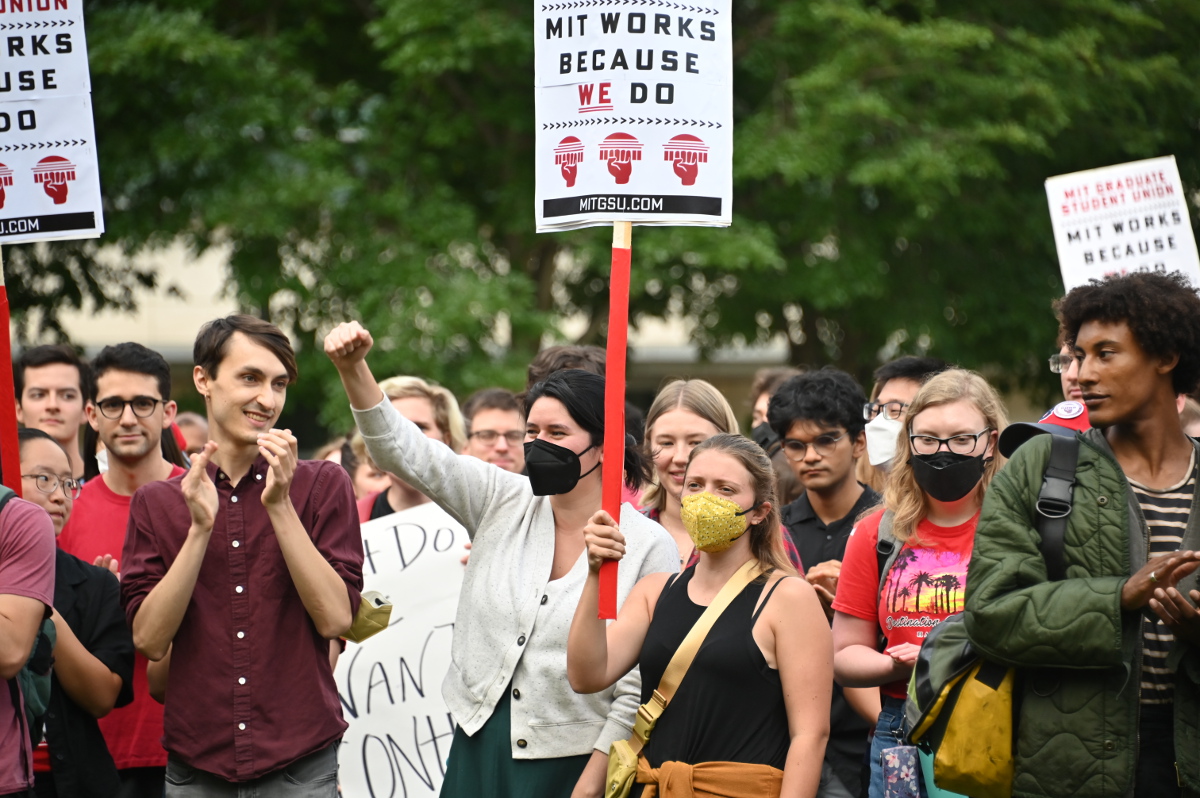 MIT graduate workers rally with signs reading MIT Works Because We Do