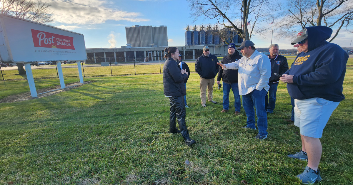 A group of workers speaking with a staff person for Senator Sherrod Brown outside the Post plant.