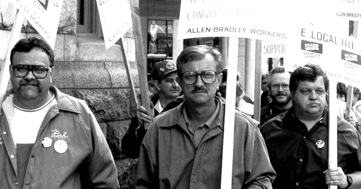 Three UE members holding picket signs