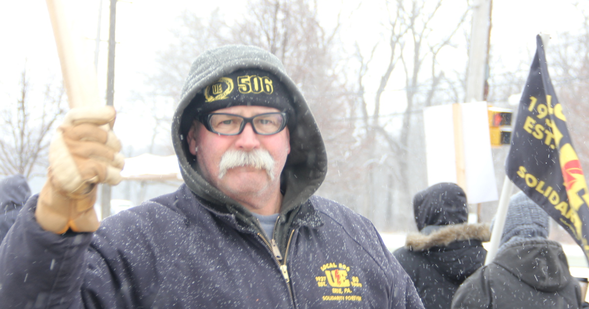Man with a UE 506 cap picketing in the snow