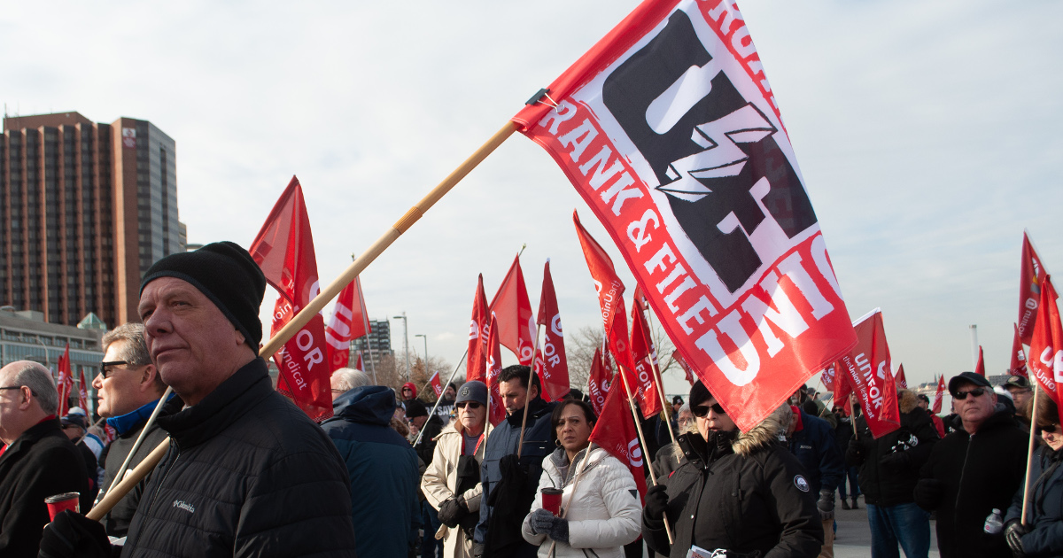 UE President Peter Knowlton holding a UE flag at Unifor rally