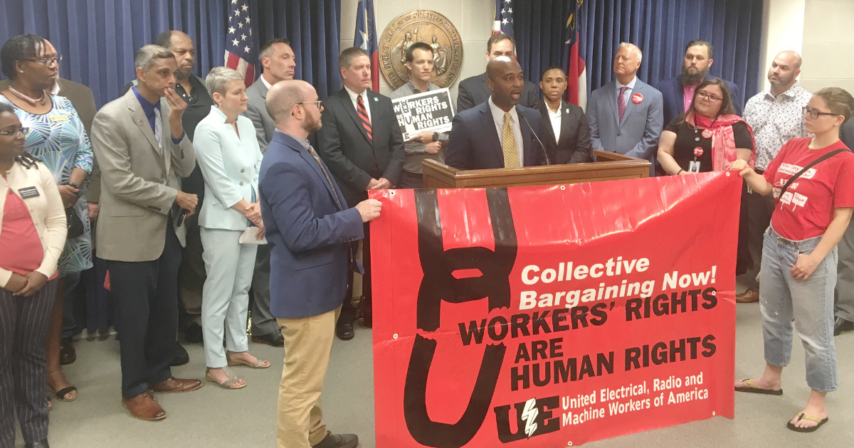 Rep. Hawkins addressing press conference behind UE banner reading "Collective Bargaining Now! Workers' Rights are Human Rights"