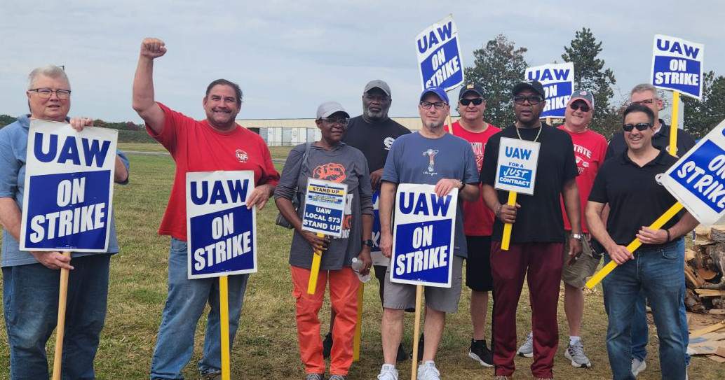 UE Local 506 and UAW Local 573 members with picket signs reading UAW on Strike