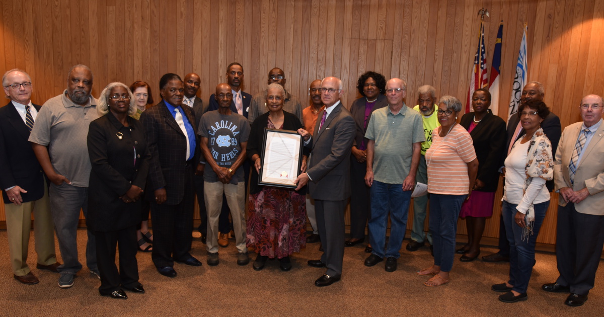 Rocky Mount Mayor David Combs presenting resolution honoring 1978 strikers to Marjorie Evans with others in attendance