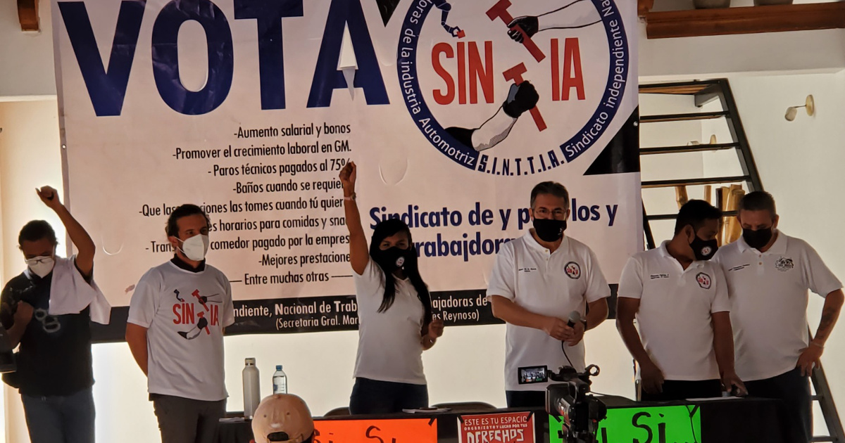 Six workers in front of a banner reading "Vota SINTTIA"
