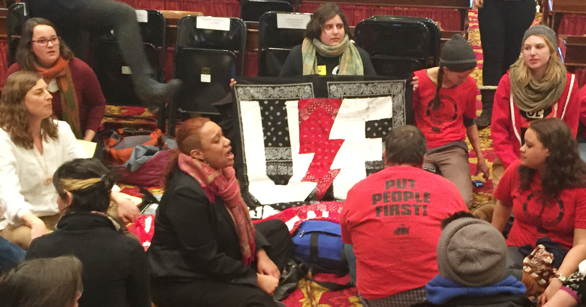 UE members and other protesters in the state legislative chamber with UE banner