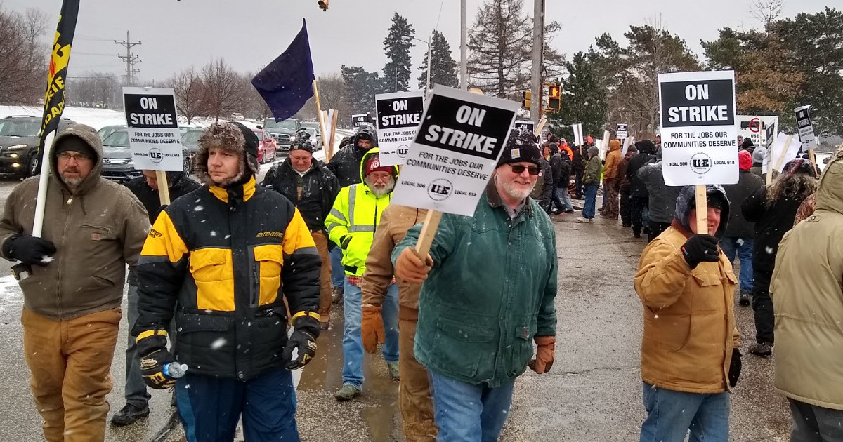 UE members picketing with signs reading "On Strike for the Jobs Our Communities Deserve"