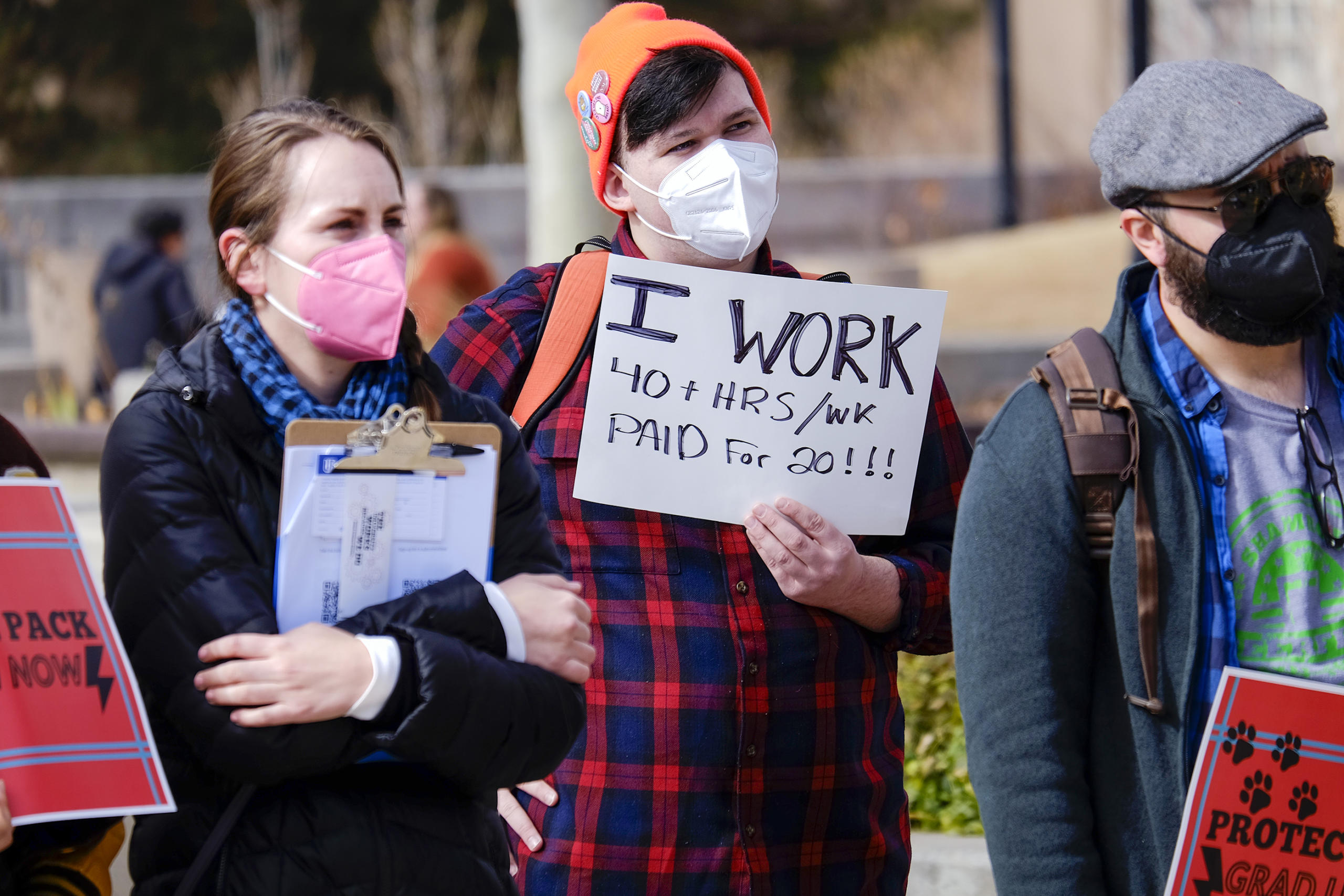 UNM graduate student and worker Peter Wood, center, holds a sign Wednesday during a rally to support collective bargaining between the university and unionized graduate workers. (Adolphe Pierre-Louis/Albuquerque Journal)