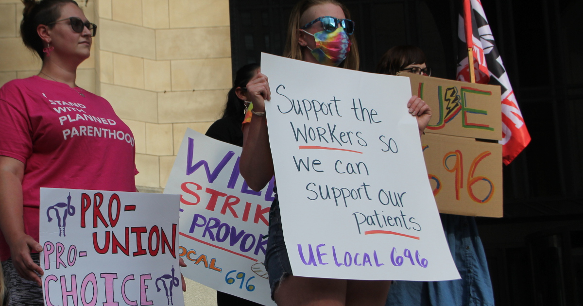 Planned Parenthood workers with signs reading Support the workers so we can support our patients UE Local 696