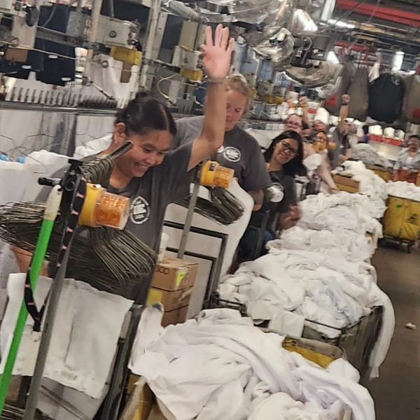 UE members wearing union t-shirts at work in an industrial laundry