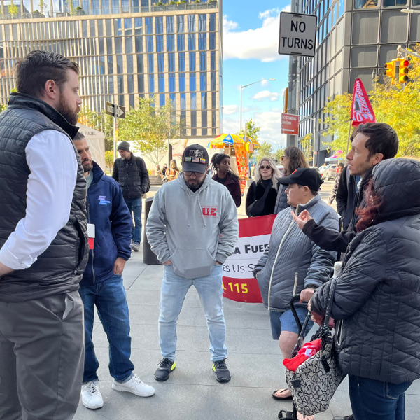 Workers talking with KKR corporate security on the sidewalk