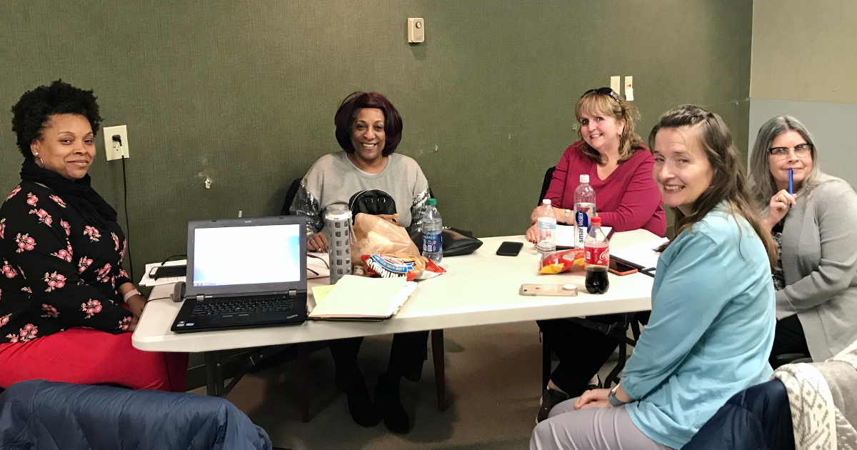 Five women sitting around a table