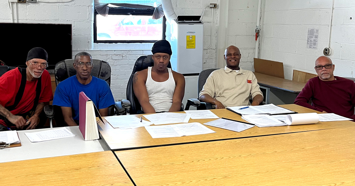 Five UE members sitting at a table