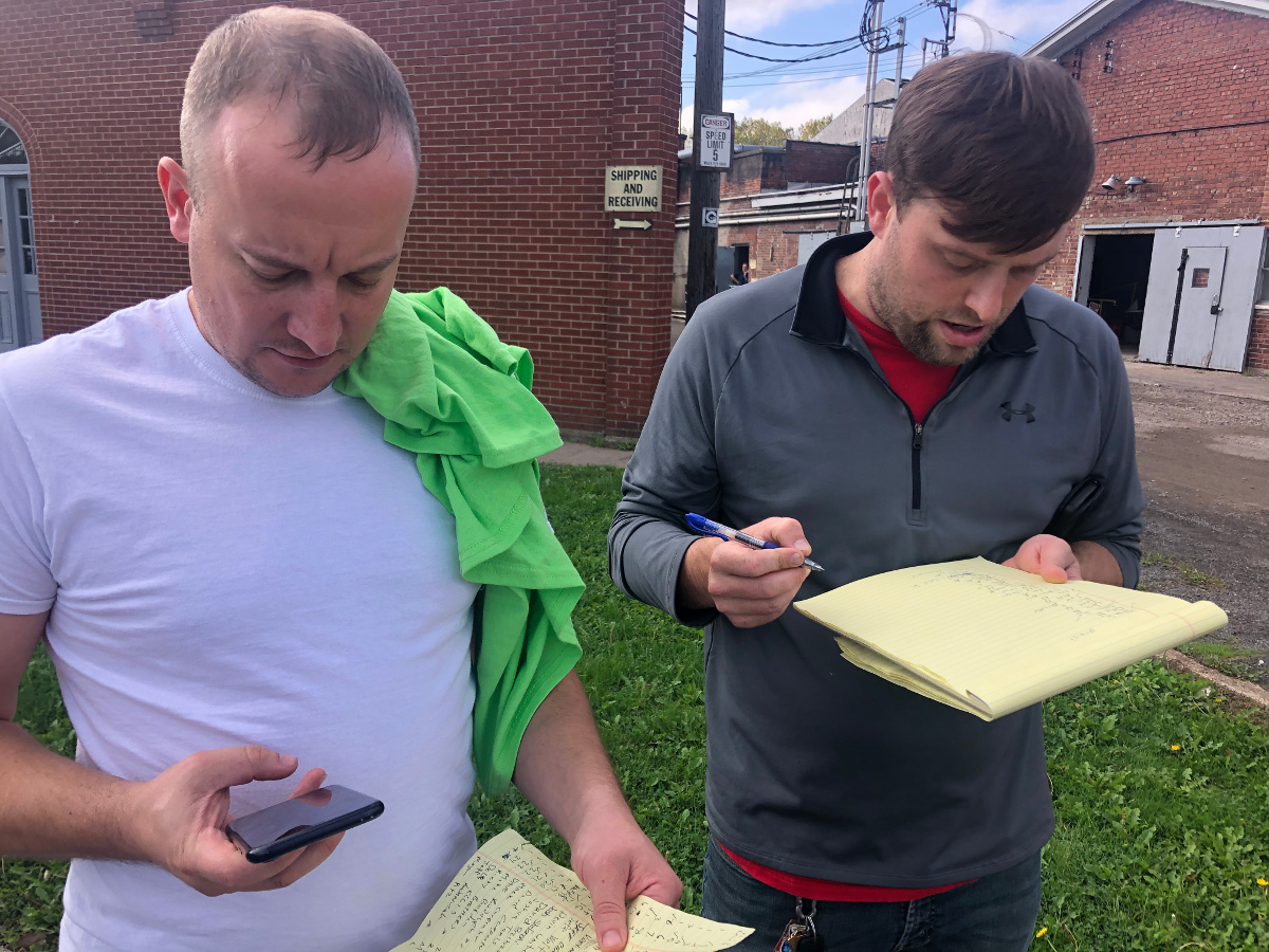 Two men checking lists