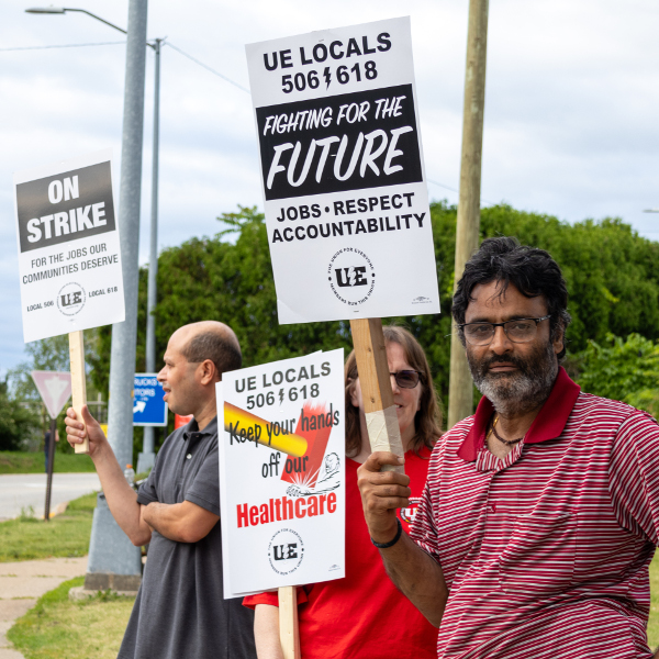 Three UE Local 506 strikers with sign reading UE Locals 506 and 618 Fighting for the Future