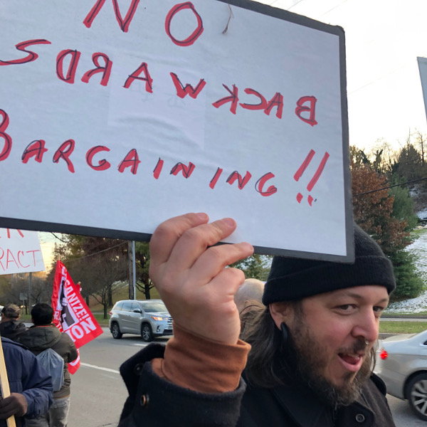 UE member holding a sign saying "No Backwards Bargaining" with the letters and word "Bargaining" written backwards