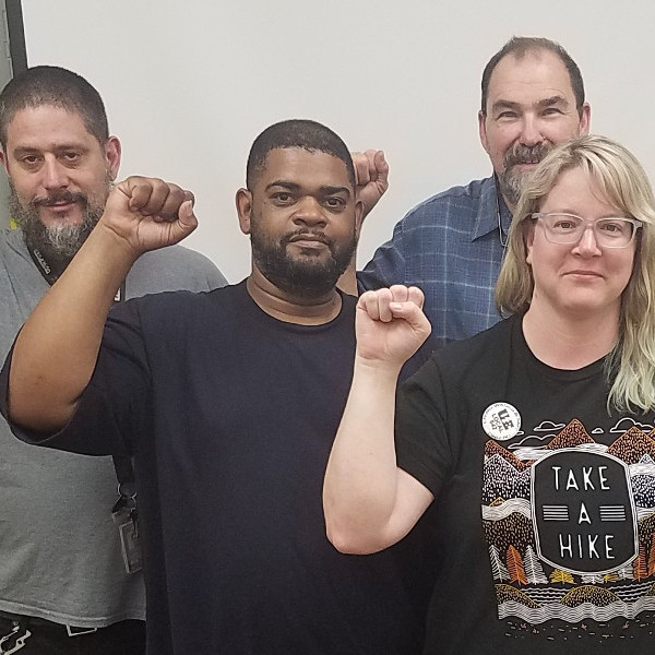 Four workers with raised fists