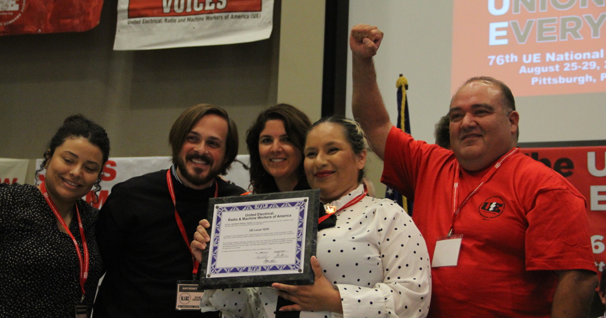 Photo of three women and two men holding a charter for UE Local 1018