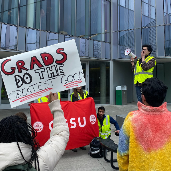 Cornell grad workers rally with sign reading Grads Do the Greatest Good