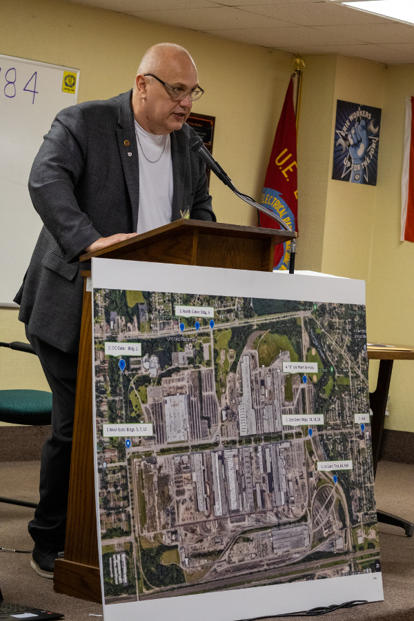 UE Eastern Region President George Waksmunski standing at a podium behind a large map of the Erie Wabtec plant.