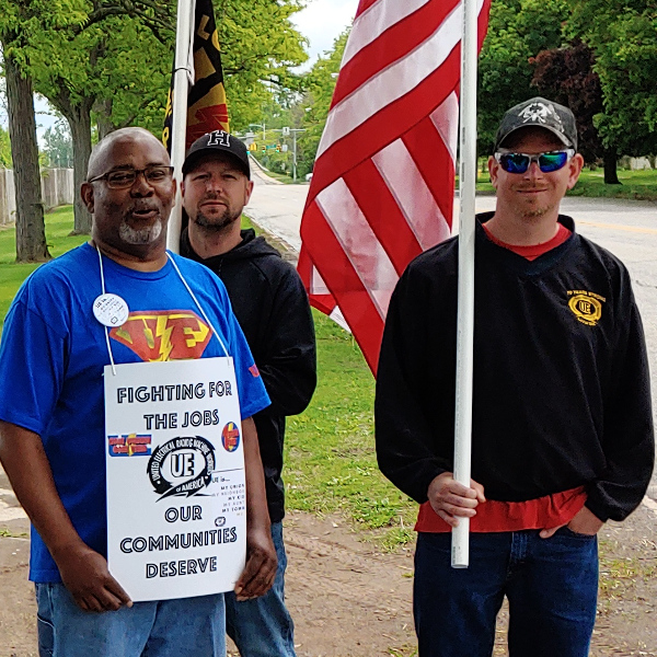 UE members picket with signs reading "Fighting for the jobs our communities deserve"