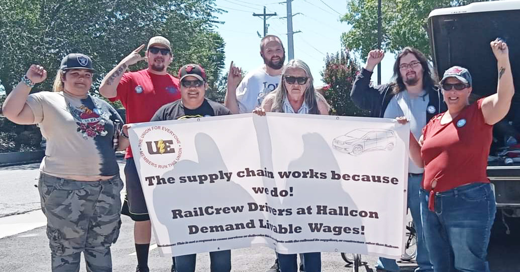 UE members with banner reading The supply chain works because we do! Railcrew drivers at Hallcon demand livable wages!