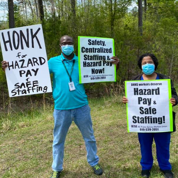 Workers with signs reading Honk for Hazard Pay and Safe Staffing