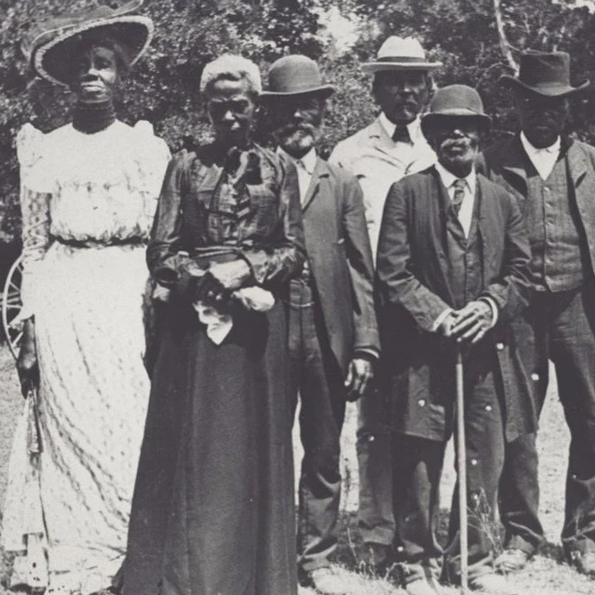A group of well-dressed Black people pose for the camera