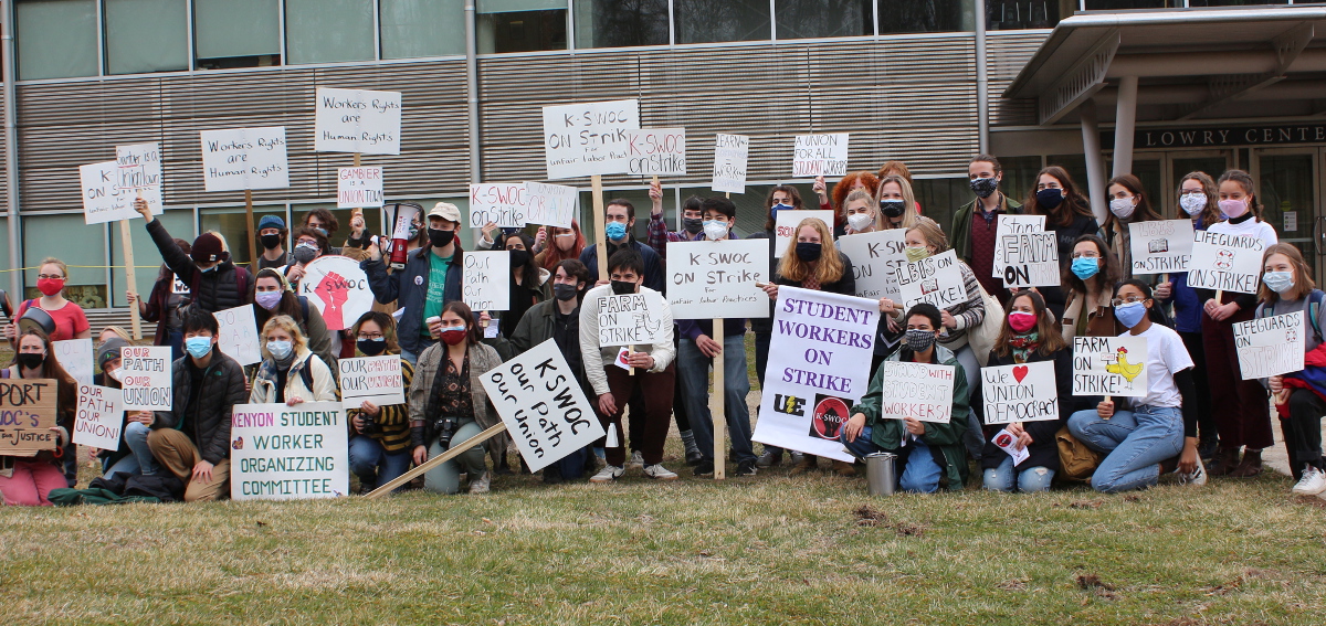 Striking Kenyon College student workers, members of K-SWOC, gather with signs in front of a college building