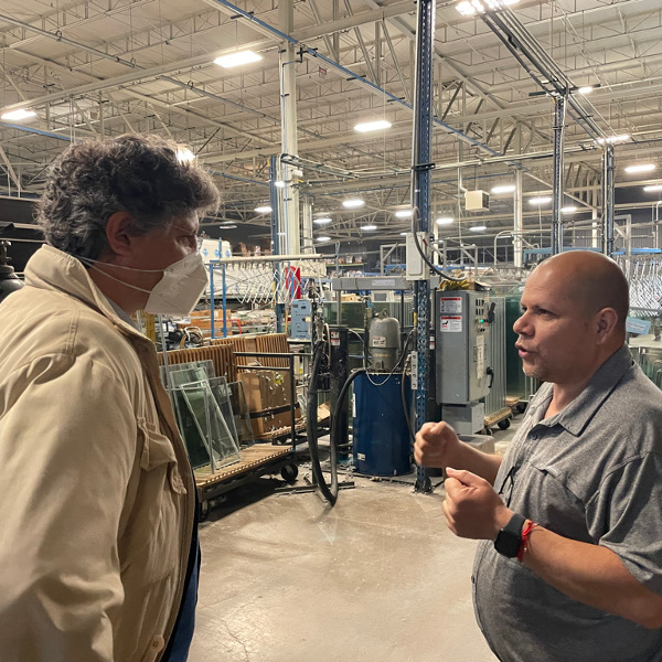 Marcello Scipioni and Armando Robles talking inside the New Era Windows Cooperative factory.