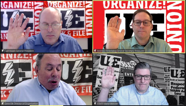 Four men on a Zoom meeting, three with right hands raised