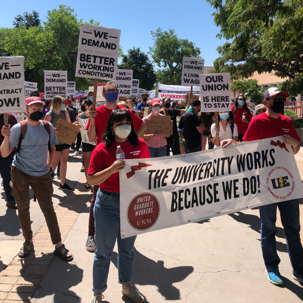 Workers with signs saying We Demand Better Working Conditions, a Living Wage, etc.